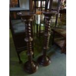 A pair of contemporary stained beechwood torcheres with rope twist and ring columns raised on