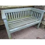 A two seat wooden garden bench with timber slatted seat and back and weathered painted finish