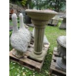 A cast composition stone two sectional bird bath, the shallow circular bowl with moulded outline