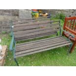 A pair of weathered contemporary two seat garden benches with stained and partially weathered timber