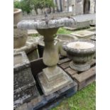 A weathered cast composition stone sundial and  combined bird bath, with brass circular dial,