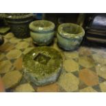 A pair of small weathered cast compositon stone garden urns of circular form with moulded rims and