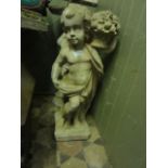 A weathered cast compostion stone garden ornament in the form of a cherub in standing pose