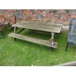 A weathered picnic table with planked top