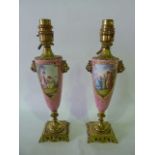 A pair of 19th century pink ground vases with painted panels to the front showing classical style