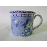 An early 19th century blue and white printed shaving mug and cover with floral decoration on a