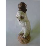 A 19th century continental oil lamp in the form of a white owl with feathery feet, raised on a rocky