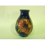 A Moorcroft blue ground vase with anemone decoration in pink and mauve, with tapering neck and