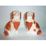 A pair of 19th century Staffordshire spaniels with rust coloured painted patches