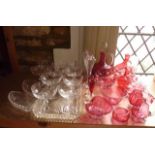 A selection of Victorian and later cranberry glass wares to include a ewer of bulbous form with