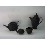 A collection of 19th century and other black basalt wares including a coffee pot with figural