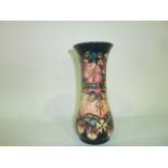 A Moorcroft vase with  honeysuckle and dog rose decoration on a dark blue and pink graduated ground,