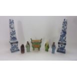 A pair of ceramic obelisks with blue and white chinoiserie style floral decoration raised on four