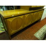 A Nathan mid 20th century low and long teak sideboard enclosed by three circular moulded panelled