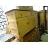 A vintage Ercol elm and beechwood sideboard of rectangular form enclosed by three doors and two