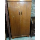 A small Art Deco style medium oak wardrobe enclosed by two full length doors with partially fitted