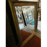 A gilt framed wall mirror of rectangular form, the bevelled edge plate set within a stepped and
