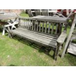 A weathered Lister teak three seat garden bench with slatted seat and back