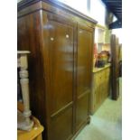 An Edwardian mahogany wardrobe in the Georgian style, the moulded cornice with dentil detail over