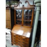 A Chippendale style reproduction mahogany bureau bookcase, the upper section with architectural