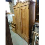 A small  continental stripped pine knockdown wardrobe, the moulded cornice with carved scrolling