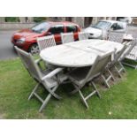 A weathered contemporary teak D end extending garden table, the slatted top with fold away leaf