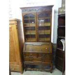 An Edwardian/1920's Jacobean revival oak bureau bookcase, the upper section with moulded cornice and