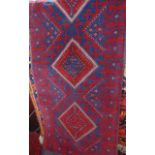 A runner in the Persian style with alternating dark blue and red ground with geometric medallion