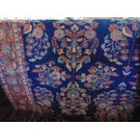 A substantial wool work carpet with deep blue ground decorated in concentric floral medallions and