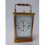 A good quality brass cased carriage clock with bevelled glazed panelled sides and front revealing