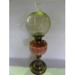 A Victorian oil lamp raised on a brass stem with fluted and further embossed detail leading to a