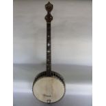 A four string banjo with mother of pearl inlay to bridge and applied faux crystal detail to head