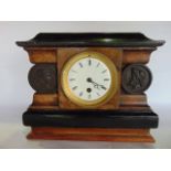 A 19th century mantle clock of classical sarcophagus form, the timber case set with burrwood veneers