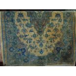 A cream ground fringed wool rug with central medallion encircled by foliate detail and pale blue