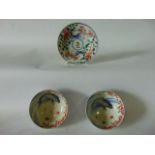 A pair of Japanese bowls with painted carp decoration to the interior, with further red blue and
