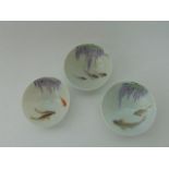 A set of three small oriental Saki bowls of the Fukagawa type, all with painted decoration of carp