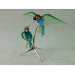 A Swarovski sculpture of a pair of bee eaters perched on two branches in the peridot colourway