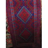 A woven wool runner with alternating red and blue field with kite shaped medallion centre