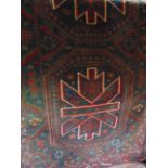 A Persian style wool rug with two central stylized geometric medallions within alternating running