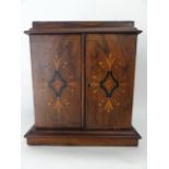 A good quality Edwardian miniature cabinet, principally in walnut veneers, the two hinged panelled
