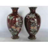 A pair of Chinese cloisonné enamel vases of baluster form with burgundy coloured ground and copper