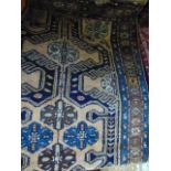 A coarse wool rug in the Persian style upon a pale brown ground with geometric medallion detail in