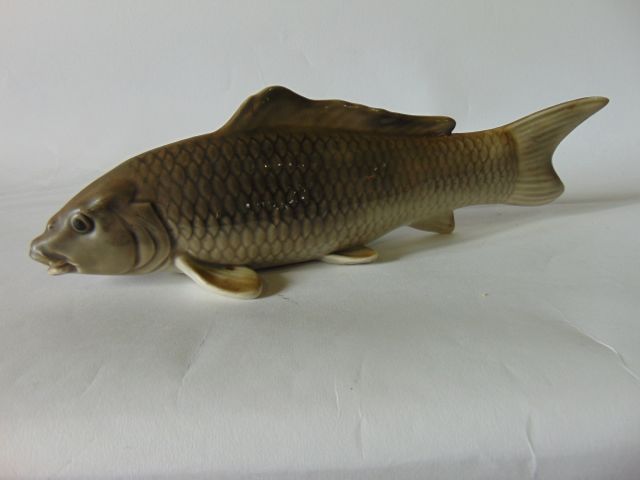 A model of a carp naturalistically modelled and painted in tones of grey, with impressed mark to