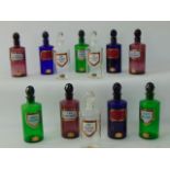 A collection of clear and coloured glass chemist bottles including blue, green and amethyst coloured
