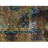 An extensive wool carpet with terracotta ground with foliate medallion centre with further