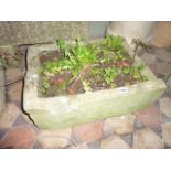 A weathered natural stone trough of rectangular form 62 cm x 43 cm approximately