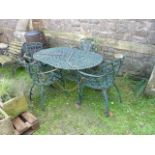 A Victorian style cast iron D end garden table with decorative scrolling detail raised on four