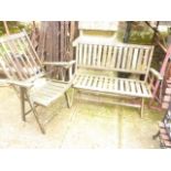 A weathered contemporary teak two seat folding garden bench with slatted seat and back together with