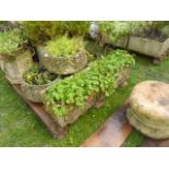 A set of three weathered cast composition stone garden planters of squat circular form with acanthus