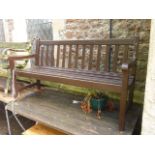 A stained hardwood three seat garden bench with slatted seat and back